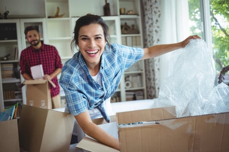 Happy couple unpacking cartons in their new house-1