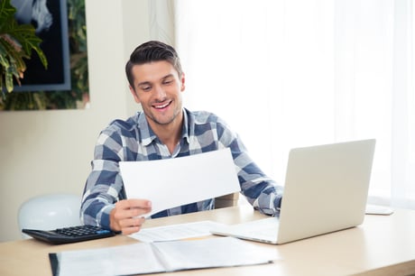 Portrait of a smiling man checking bills on the tablet at home-2